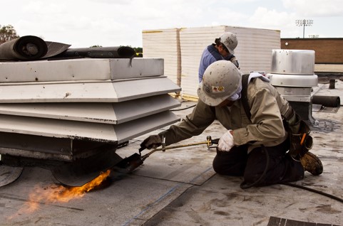 Waukegan Roofing employee welding industrial roof